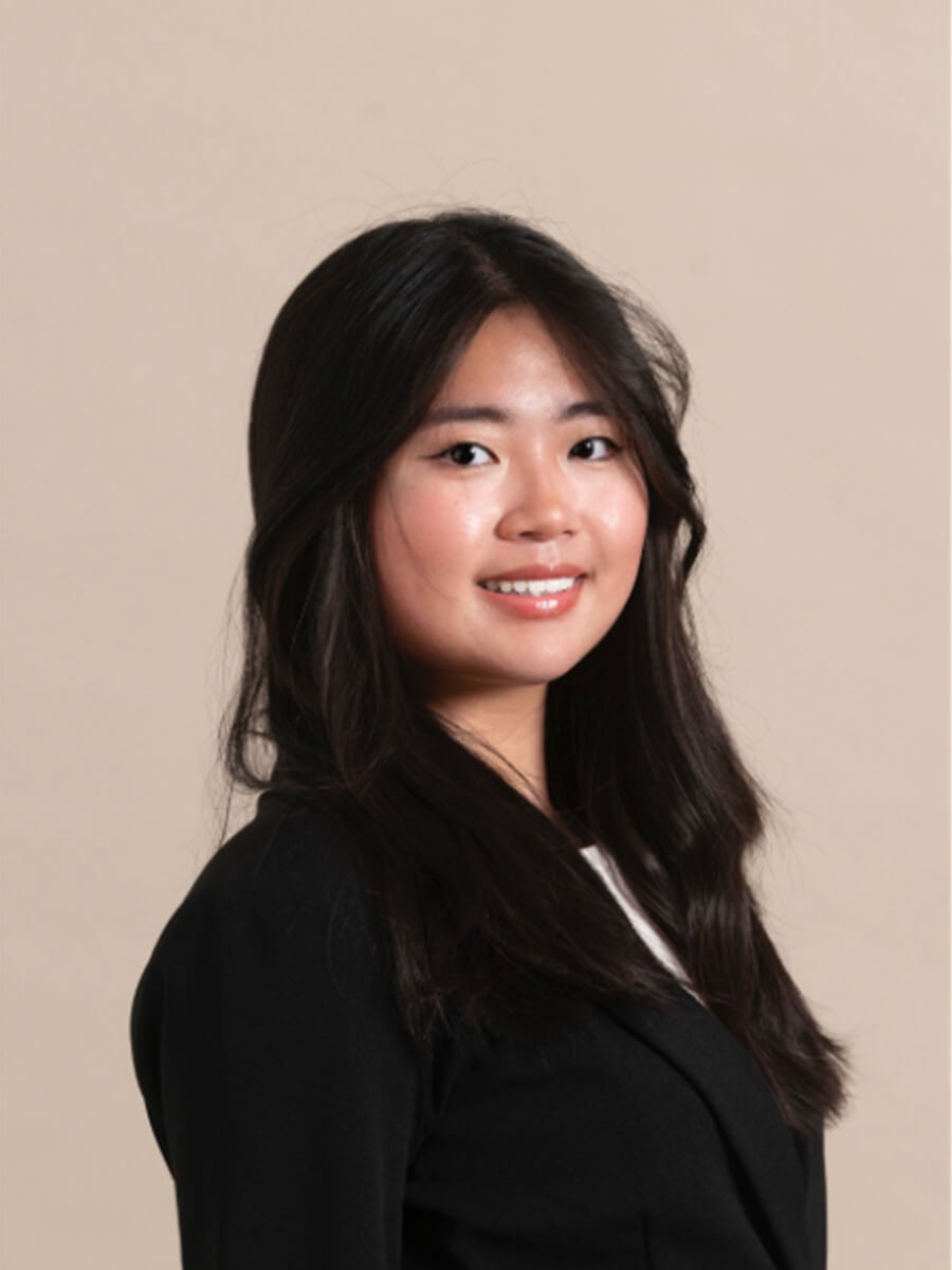 Jamie's headshot features a woman smiling while posed to the right. She wears a black suit.