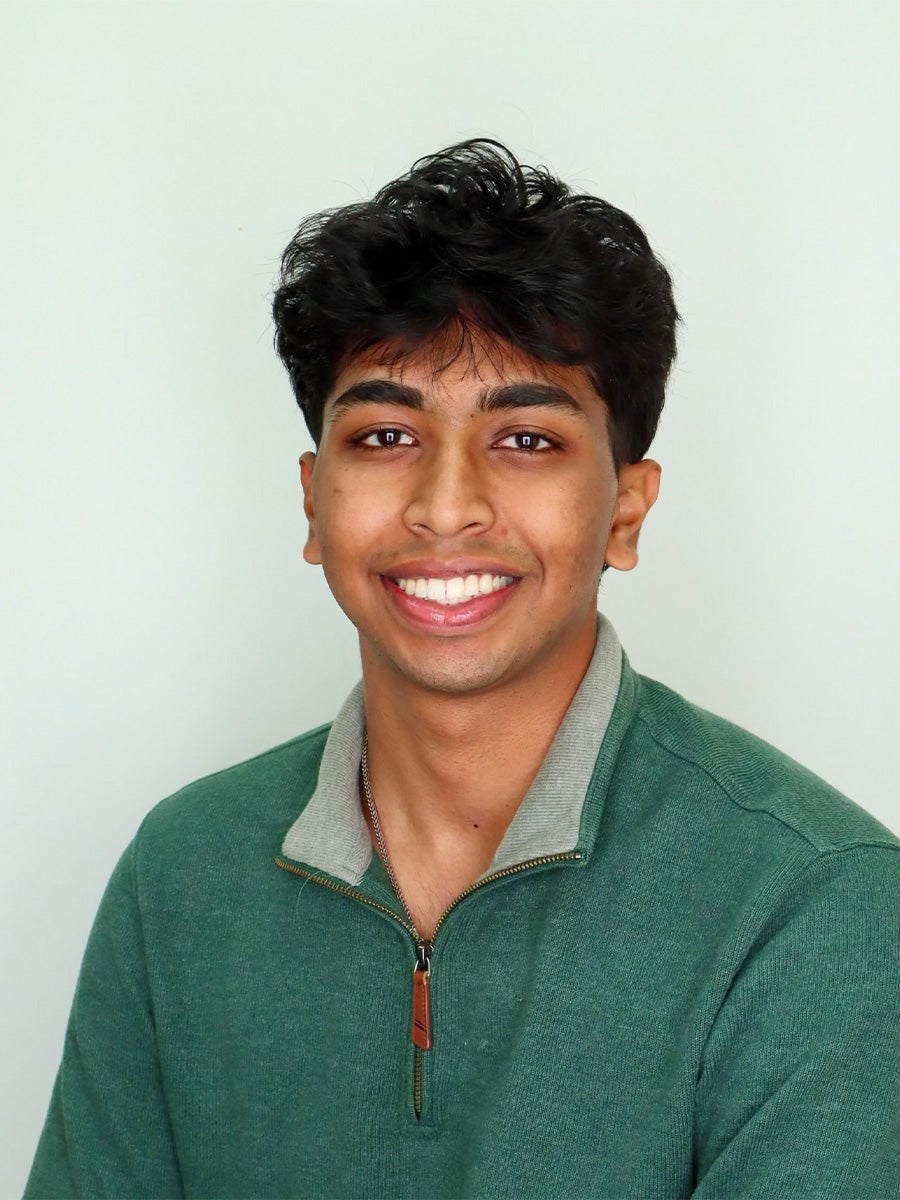 headshot of student wearing a green collard pullover 