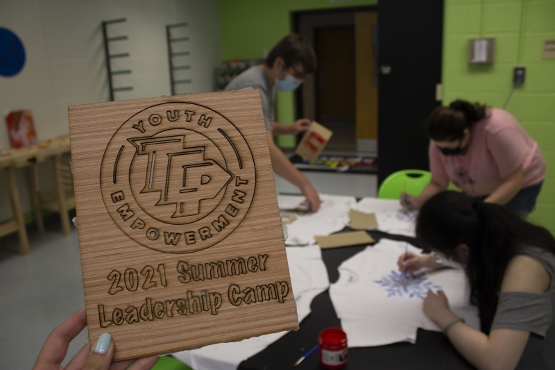 picture of wooden carved sign that reads "TCP Academy" 