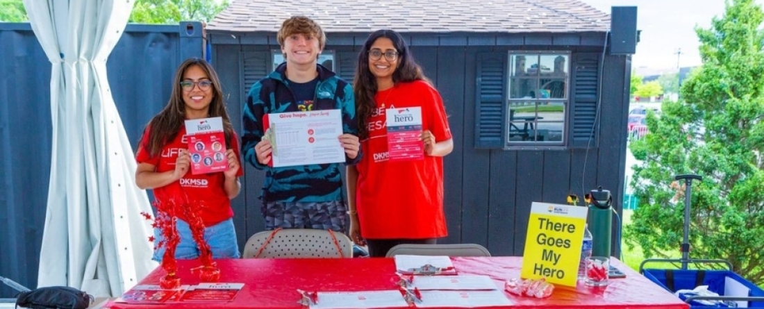 Students smiling while holding paper