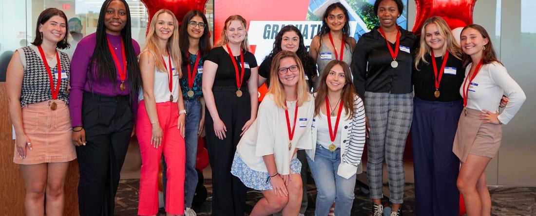 Students posing for a photo while wearing a medallion